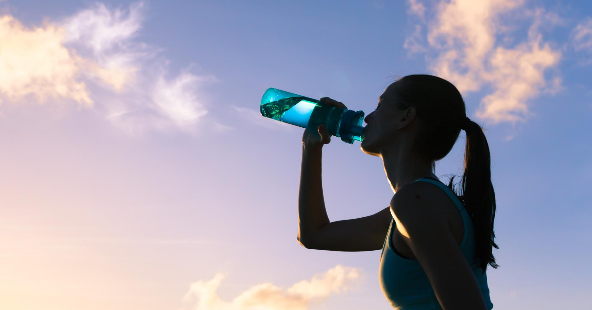 Woman drinking from a water bottle.