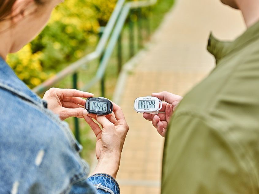 Couple looking at their daily step count on their 3DFitBud Simple Step Counters