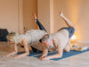 Older couple doing yoga felxibility exercises in their living room