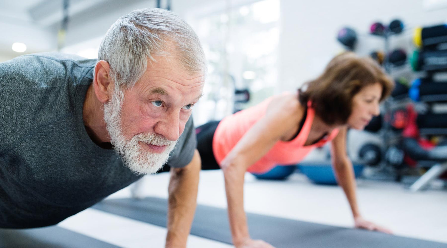 Senior couple working out indoors. Old man doing push-ups. Home workouts for seniors