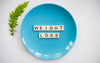 Empty blue plate with scrabble letters spelling weight loss.