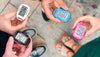 Overhead shot of four people holding 3DFitBud pedometer on their hands comparing their step count